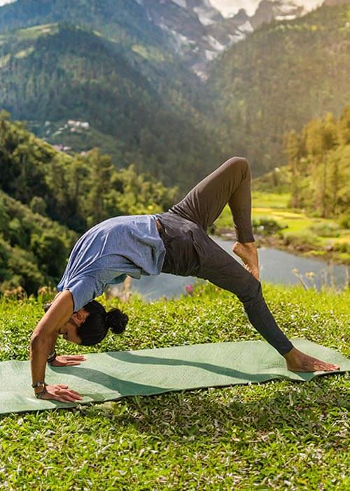 Tapis de yoga antidérapant latex et PU - Yogini réalise une posture inversée sur un tapis de yoga vert en pleine nature | Achamana